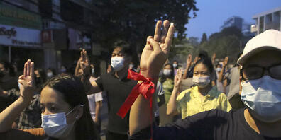 Mehrere Demonstranten heben ihre Hand zum Dreifingergruß während einer Kundgebung in Yangon. Foto: Uncredited/AP/dpa
