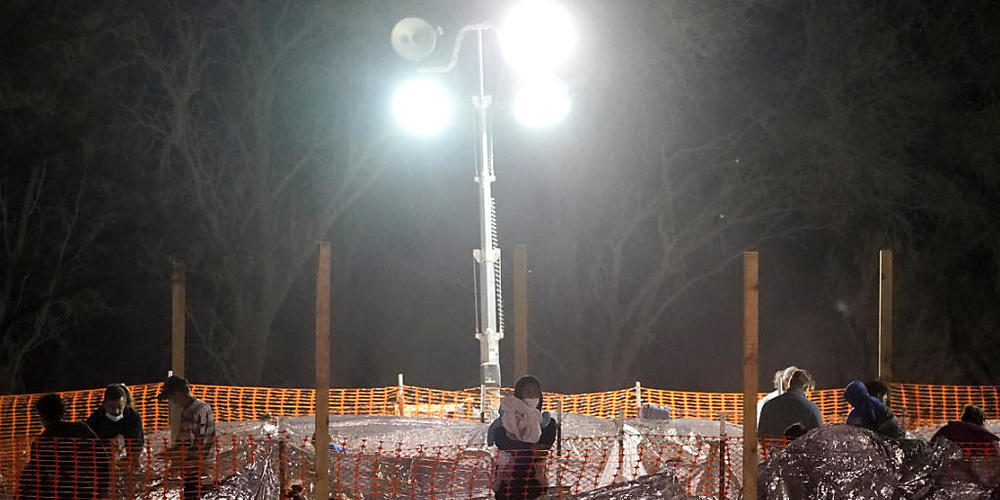 Eine Frau trägt ein Kind an der Grenze zwischen USA und Mexiko unter der internationalen Anzalduas-Brücke, nachdem sie von einem US-Zoll- und Grenzschutzbeamten in Gewahrsam genommen wurden. Foto: Julio Cortez/AP/dpa