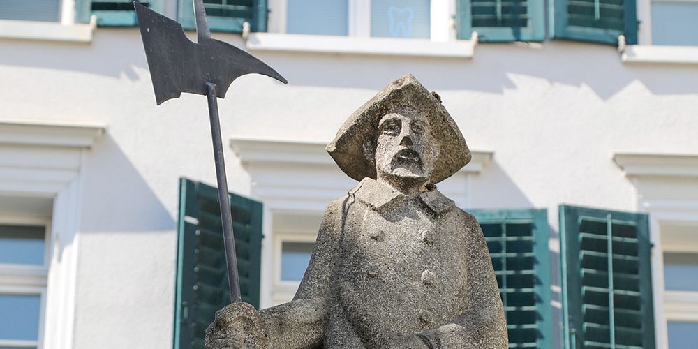 Auf dem Brunnen beim Rathaus thront zum Gedenken an Reinhard Spiess, den letzten Nachtwächter der Schweiz, eine Statue von Otto Rausch (1984)