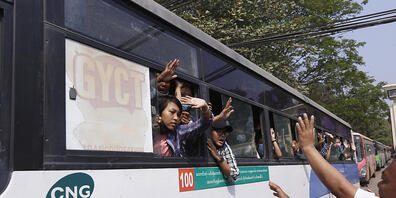 Festgenommene Demonstranten winken Menschen, während sie in einem Bus sitzen, der aus dem Insein-Gefängnis kommt und sie zu einem ungenannten Ort transportieren wird. Foto: Uncredited/AP/dpa