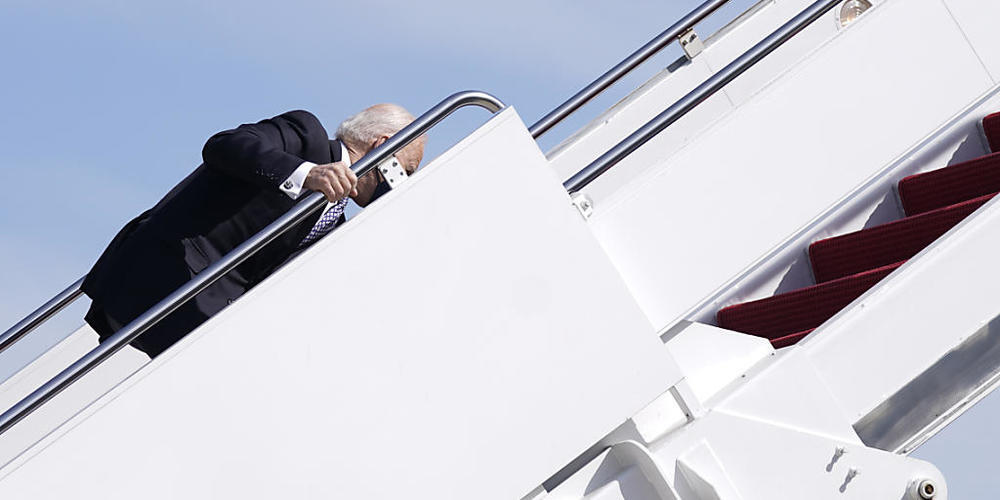 Joe Biden, Präsident der USA, hält sich am Geländer der Gangway fest, nachdem er beim Einsteigen in die Air Force One auf der Treppe gestolpert ist. Foto: Patrick Semansky/AP/dpa