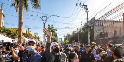 HANDOUT - Auf diesem vom Präsidentenamt von El Salvador zur Verfügung gestellten Bild winkt Nayib Bukele (M., l), Präsident von El Salvador, Anhängern zu, während er mit seiner Frau Gabriela Rodriguez (M., r) zum Wahllokal kommt. Foto: ---/Prensa ...