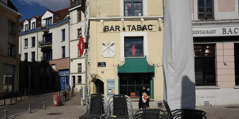 Stühle sind in einer leeren Fußgängerzone vor einem Café aufeinandergestapelt. Frankreich verhängt im Kampf gegen die Corona-Pandemie regionale Ausgangsbeschränkungen. Foto: Michel Spingler/AP/dpa
