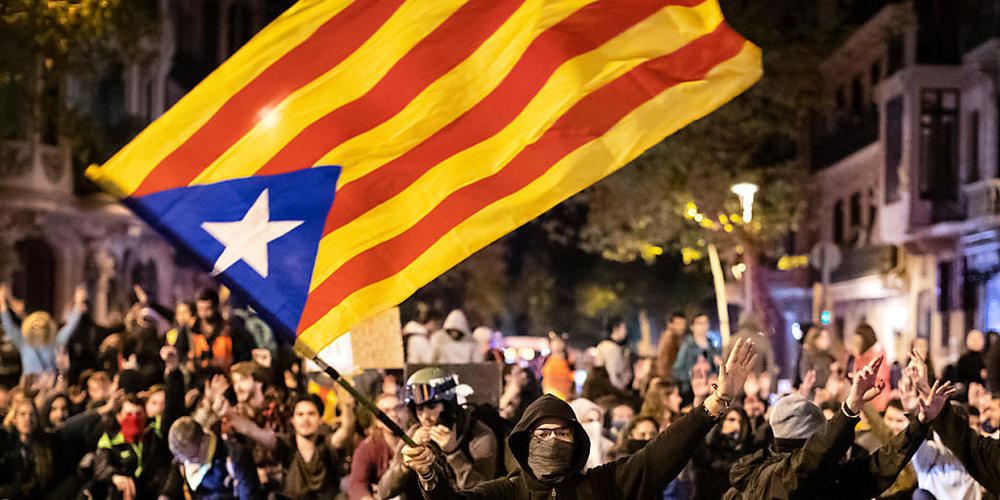 ARCHIV - Ein Befürworter der Unabhängigkeit Kataloniens schwenkt während einer Demonstration eine katalanische Fahne. Foto: Ben Curtis/AP/dpa
