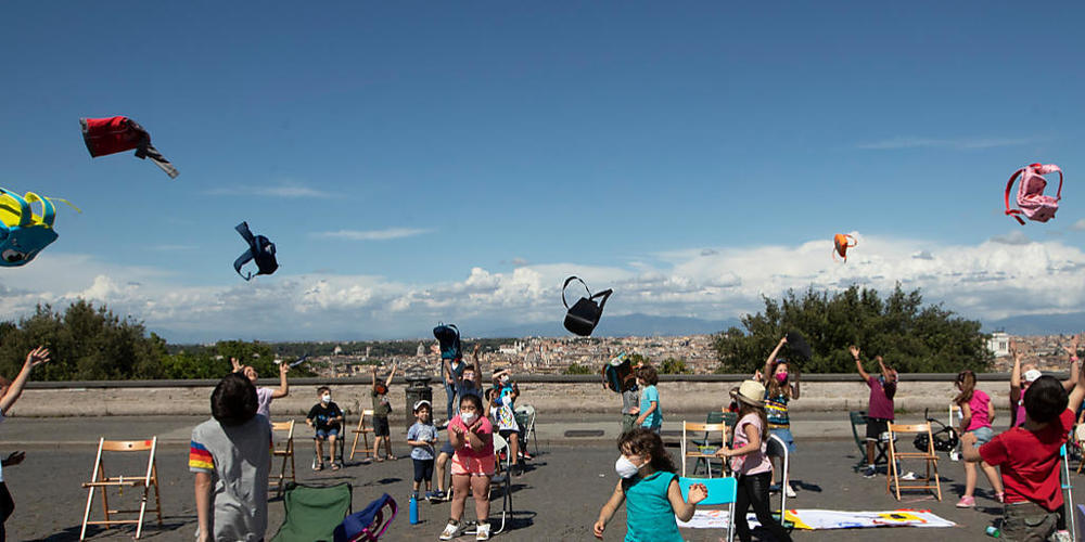 ARCHIV - Schulkinder werfen im Rahmen des Flashmobs «Apriti Scuola!» (Öffnet die Schule) auf dem Hügel Gianicolo ihre Schulranzen in die Luft. Foto: Alessandra Tarantino/AP/dpa