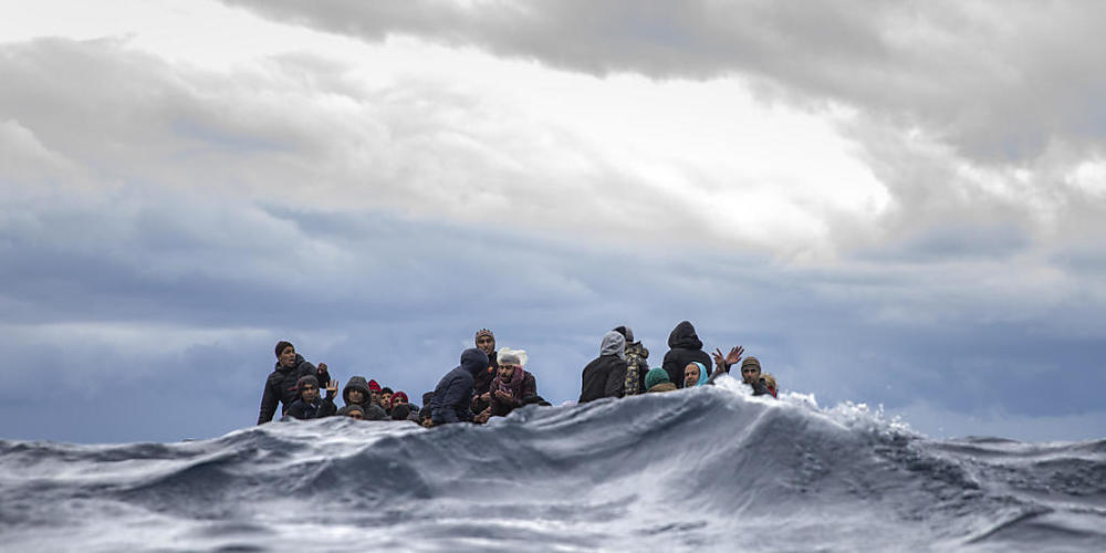 ARCHIV - Männer aus Marokko und Bangladesch sitzen in einem überfüllten Holzboot im Mittelmeer vor der Küste von Libyen. Foto: Santi Palacios/AP/dpa