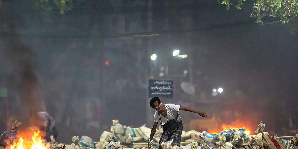 Ein Demonstrant stapelt Säcke auf einer Straße in Yangon. Foto: Theint Mon Soe/SOPA Images via ZUMA Wire/dpa