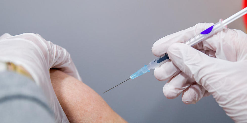 Ein Senior wird von einer medizinischen Fachkraft geimpft. Foto: Daniel Karmann/dpa