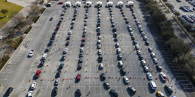 ARCHIV - Autos stehen auf einem Parkplatz in Houston Schlange - die Insaßen warten darauf, gegen das Coronavirus geimpft zu werden. Foto: Mark Mulligan/Houston Chronicle/AP/dpa - ACHTUNG: Nur zur redaktionellen Verwendung und nur mit vollständiger...