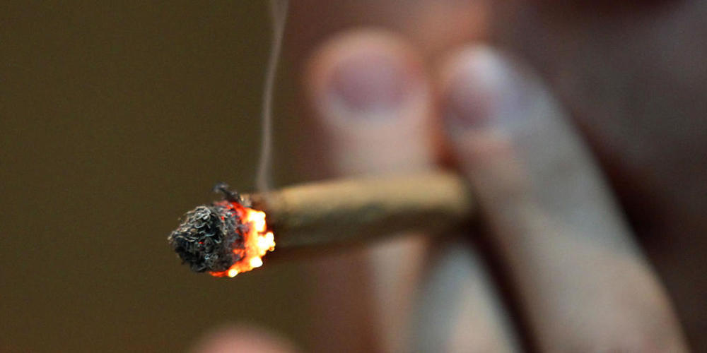 ARCHIV - ILLUSTRATION - Ein Mann raucht in einem Coffee Shop einen Joint mit Marihuana. Foto: picture alliance / Oliver Berg/dpa