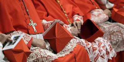 ARCHIV - Mehrere Kardinäle sitzen mit ihren Biretta-Hüten im Schoß in der Peterskirche. Wegen finanzieller Schwierigkeiten unter anderem durch die Corona-Pandemie hat Papst Franziskus die Gehälter von Kardinälen und Kurienchefs gekürzt. Foto: Andr...