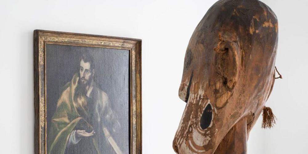 Eine Frauenfigur aus Papua-Neuguinea betrachtet in der Ausstellung "Making the World" ein Bildnis des Apostel Jakobus d. Ä. aus der Schule des El Greco.