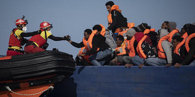 ARCHIV - Migranten aus Eritrea, Ägypten, Syrien und dem Sudan werden an Bord eines Holzbootes im Mittelmeer etwa 110 Meilen nördlich von Libyen darauf, von Helfern der spanischen NGO «Open Arms» unterstützt. (Illustration zu dpa: "Hilfsorganisatio...