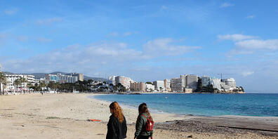 ARCHIV - Zwei junge Frauen gehen am leeren Strand von Magaluf entlang. Foto: Clara Margais/dpa