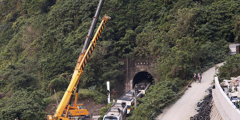 Rettungskräfte entfernen ein Teil eines entgleisten Zuges. Bei einem schweren Zugunglück in Taiwan sind am 02.04.2021 mindestens 51 Menschen ums Leben gekommen. Foto: Chiang Ying-Ying/AP/dpa