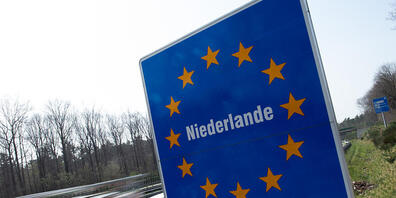 Ein Schild weist an der Autobahn 52 auf den Grenzübergang zu den Niederlanden hin. Foto: Federico Gambarini/dpa
