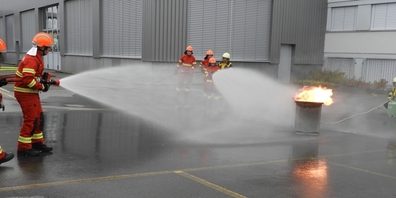 Jugendfeuerwehrler bei der Löschung eines Feuers mit Wasser aus einer Motorspritze.