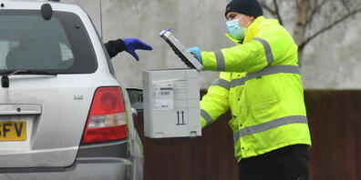 ARCHIV - In einem Corona-Testzentrum wirft ein Fahrer aus dem Auto ein Testkit in eine Box. Die Bürger in England sollen sich bald zweimal pro Woche kostenlos auf das Coronavirus testen lassen können. Foto: Jacob King/PA Wire/dpa