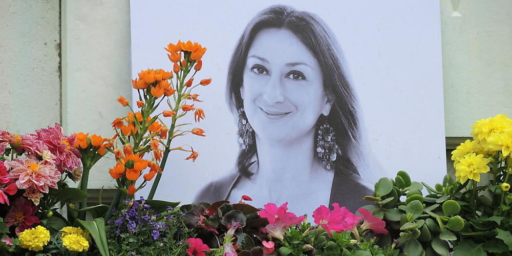 ARCHIV - Kerzen und Blumen stehen im Gedenken vor einem Foto der ermordeten maltesischen Journalistin Daphne Caruana Galizia vor dem Justizpalast. Foto: Lena Klimkeit/dpa