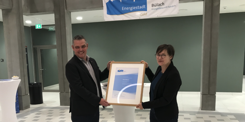 Katrin Bernath, Präsidentin des Trägervereins Energiestadt und Stadträtin von Schaffhausen, übergibt im Bülacher Stadthaus das Zertifikat «Gold» an Stadtrat Andreas Müller.