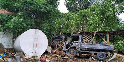 Das Wrack eines Pick-ups liegt auf einem Haufen Trümmern. Foto: Rofinus Monteiro/AP/dpa