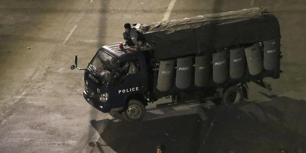 Polizisten sitzen in einem Lastwagen und fahren Patrouille in Yangon. Foto: Uncredited/AP/dpa