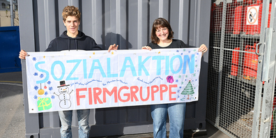 Religionspädagogin Patricia Neuner (rechts) hält zusammen mit Firmand Matteo das von den Mädchen angefertigte Banner der Sozialaktion hoch. 