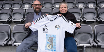 Neben Stefan Grob (Bereichsleiter Arbeit Stiftung Heimstätten Wil) sehen wir die Gewinnerin der Trikotaktion. Normalerweise arbeitet sie in der Schreinerwerkstatt der Heimstätten und wirkt auch dort künstlerisch mit