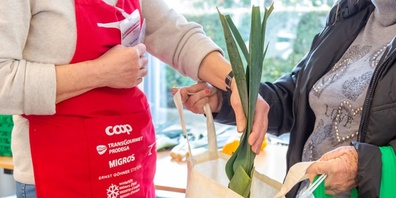 Eine Kundin erhält Lebensmittel an einer Abgabestelle von Tischlein deck dich.