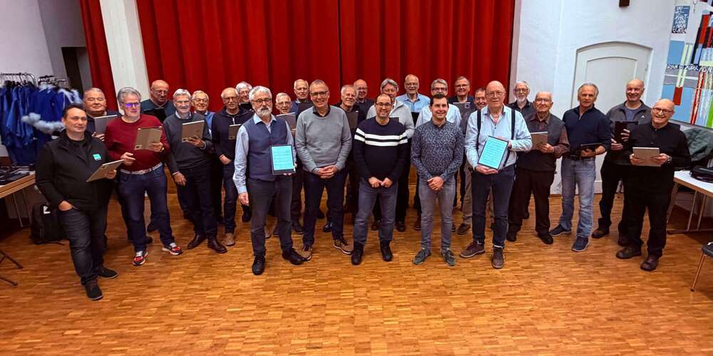 Männerchor Au Berneck mit Tablets. Im Vordergrund die Drahtzieher (von links): Charles Martignoni (Vorstand), Ivo Riedi (Präsident OMR), Pascal Rohrer (Schulleitung und IT), Oliver Morandi (Leitung IT OMR), July Thurnheer (Vorstand Männerchor Au Berneck). Ganz links Dirigent Mihai Alexa.