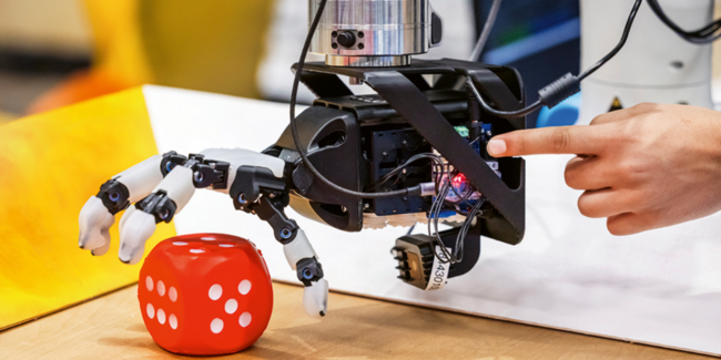 Eine Roboterhand, angetrieben durch künstliche Sehnen, führt selbstständig eine Lernaufgabe aus.