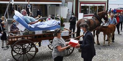Übergabe der Petiton für den Erhalt eines Spitals am 30. April vor dem Rathaus in Appenzell: Heidi Fässler-Koller überreicht Ratsschreiber Markus Dörig die rote Schachtel mit den Unterschriftenbögen. Im Hintergrund Albert Rusch im symbolischen Spi...